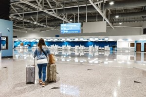 Flo Formación - mujer con maletas en aeropuerto